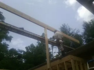 Carpenter setting a ridge beam over a new addition frame — Ice Dam Removal by Roofing Brothers in Topsham