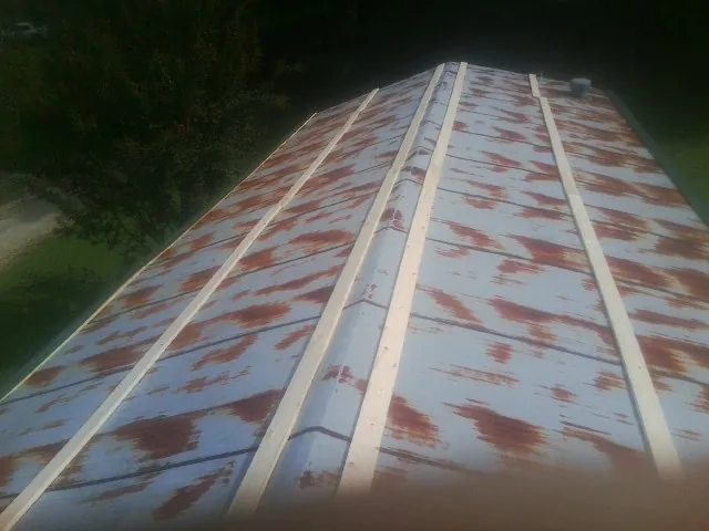 Rusted metal roof panels with new wood purlins before replacement — Storm Damage Roof Repair in Topsham by Roofing Brothers