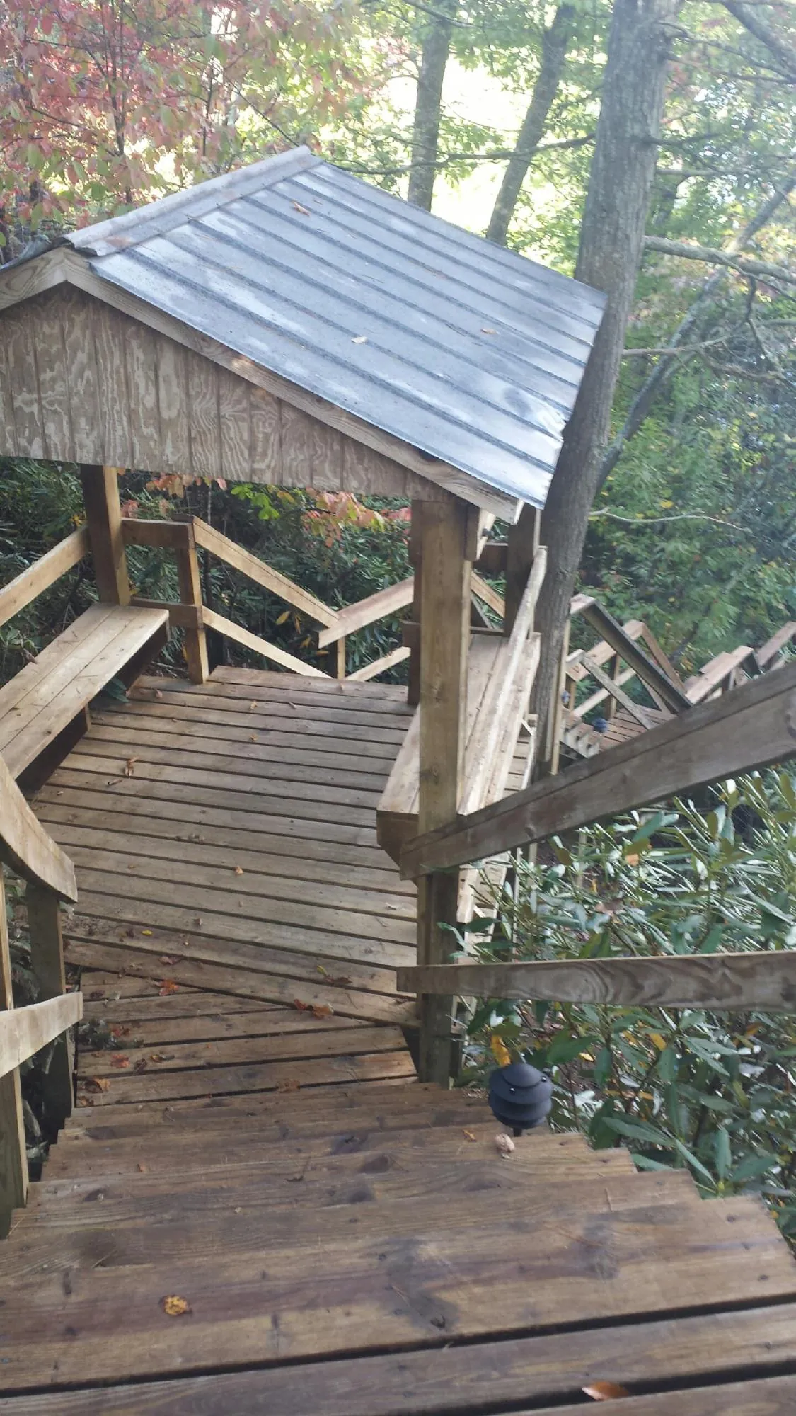Metal roofed shelter over wooden steps on a wooded walkway — Skylight Repair & Installation work by our crew in Topsham